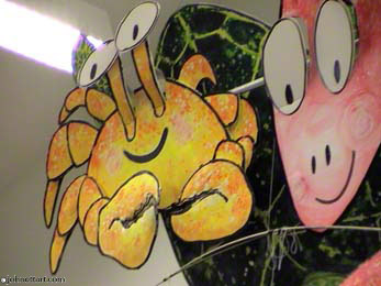 Crabby and friends hang out above kids in the school library