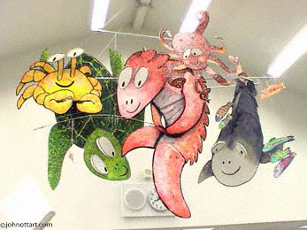a fish, a crab, a green turtle and an octopus use a real fishing pole in this library mobile